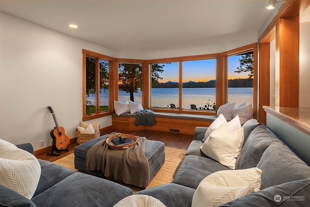 living room with light hardwood / wood-style flooring and a water view