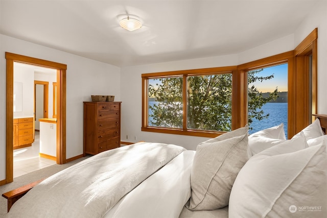 tiled bedroom featuring a water view and ensuite bathroom