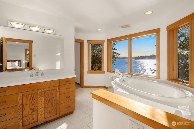 bathroom featuring vanity, tiled tub, tile patterned floors, and a water view