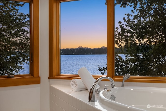 bathroom with a bathing tub and a water view