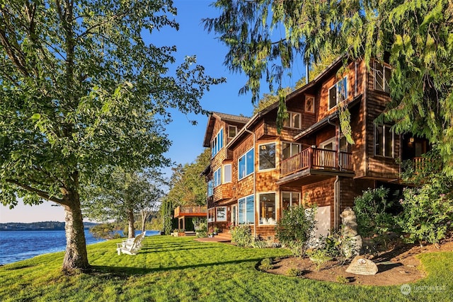 rear view of property with a lawn and a water view