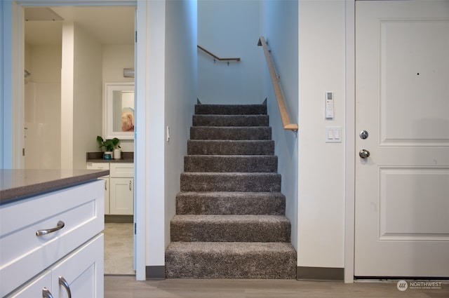 stairway with light hardwood / wood-style floors