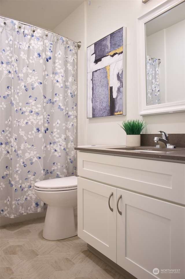 bathroom featuring toilet, vanity, and tile patterned flooring