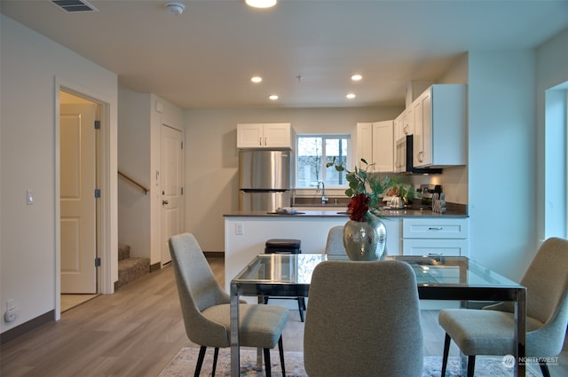 dining area with light hardwood / wood-style flooring and sink