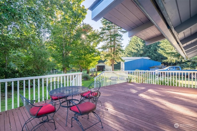 wooden terrace with a lawn and a storage unit