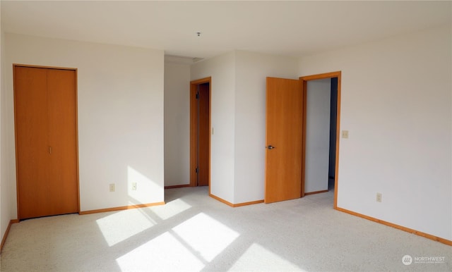 unfurnished bedroom featuring baseboards and light colored carpet