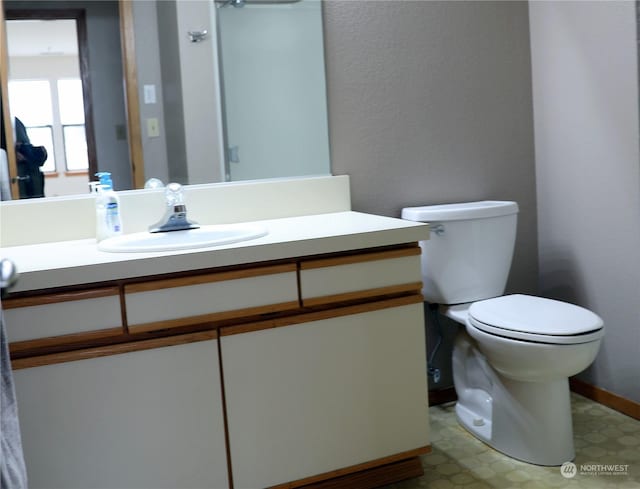 bathroom featuring baseboards, vanity, toilet, and tile patterned floors