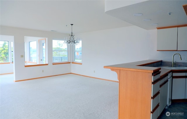 kitchen featuring pendant lighting, dark carpet, an inviting chandelier, a sink, and baseboards