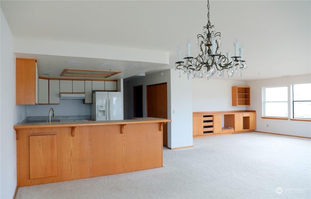 kitchen featuring white refrigerator with ice dispenser, light countertops, light carpet, a peninsula, and under cabinet range hood