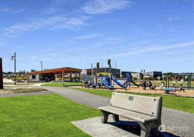 view of property's community featuring playground community and a lawn