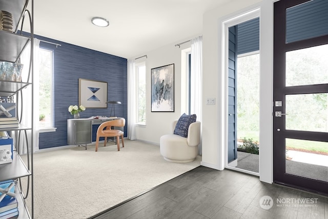 interior space with an accent wall, dark wood-type flooring, baseboards, dark colored carpet, and wallpapered walls