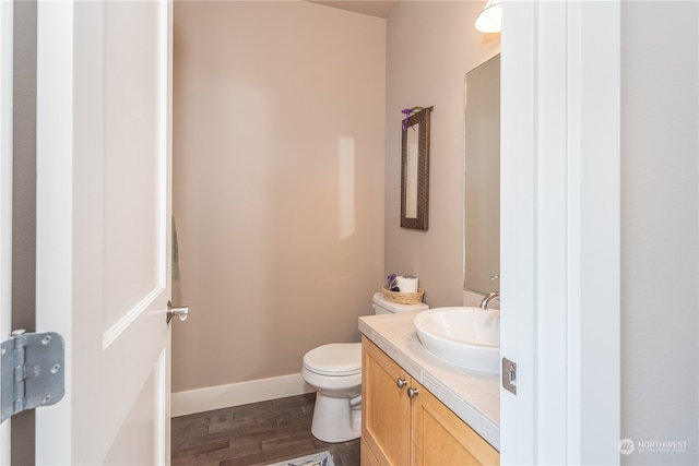 bathroom featuring hardwood / wood-style floors, vanity, and toilet