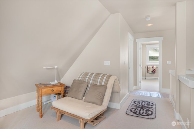 living area featuring vaulted ceiling and light colored carpet