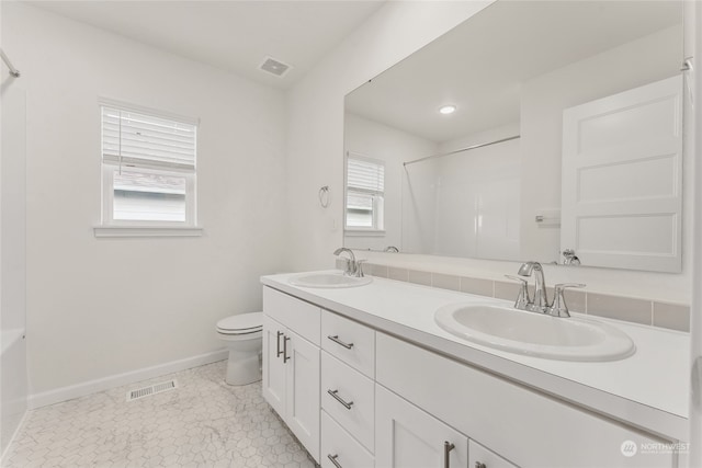 bathroom featuring vanity, toilet, tile patterned flooring, and a wealth of natural light