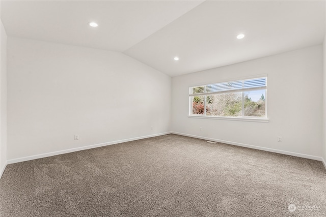 carpeted empty room featuring vaulted ceiling