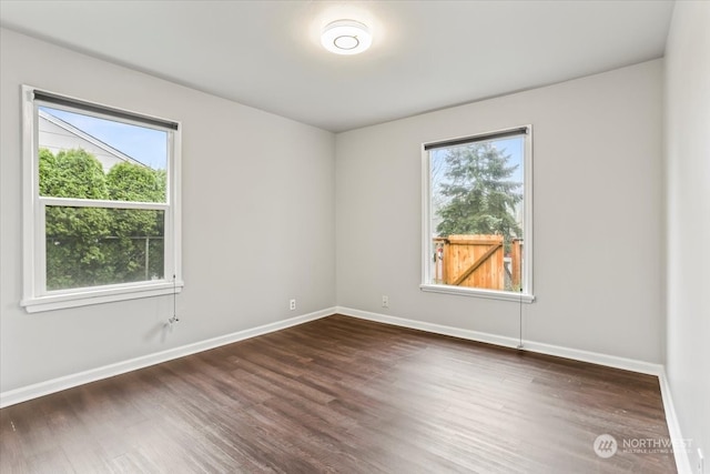 unfurnished room with dark wood-type flooring and a healthy amount of sunlight