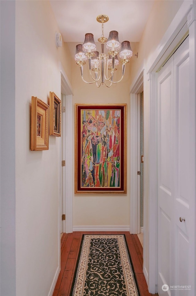 hall featuring hardwood / wood-style floors and a notable chandelier