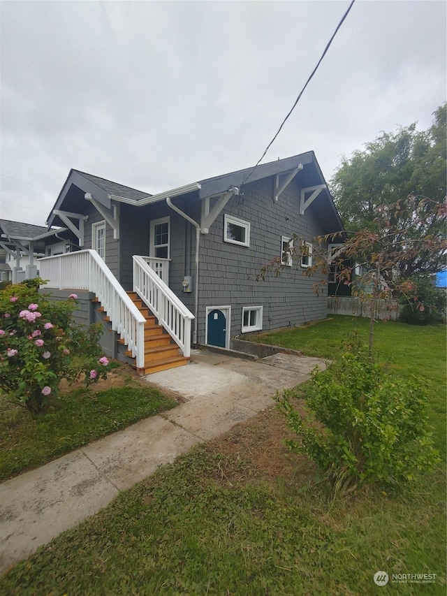 view of side of home featuring a yard and fence