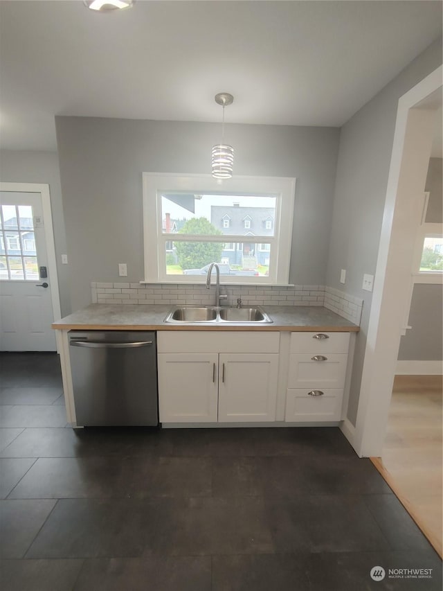 kitchen with light countertops, white cabinets, a sink, and stainless steel dishwasher