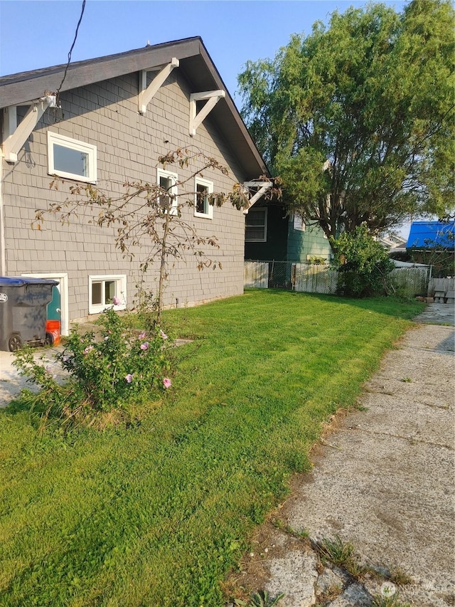 view of side of property with a yard and fence