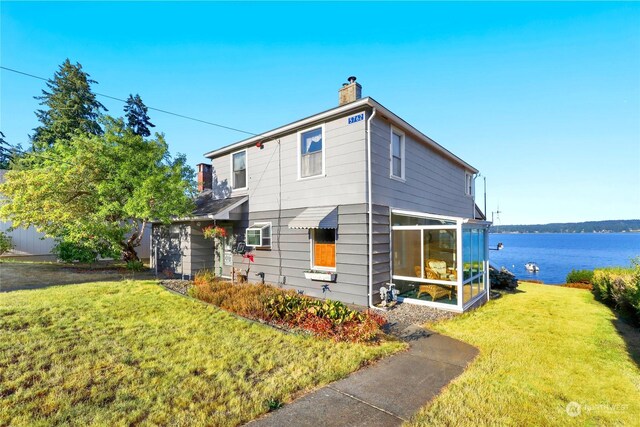 exterior space with a water view and a lawn