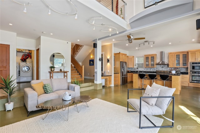 living room with washing machine and dryer and ceiling fan