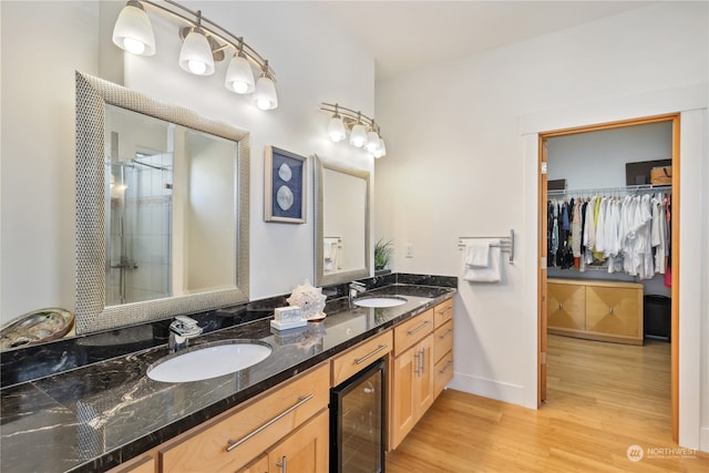 bathroom with wine cooler, a shower with door, vanity, and hardwood / wood-style flooring