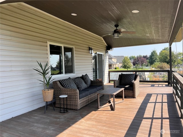 wooden deck with an outdoor living space and ceiling fan