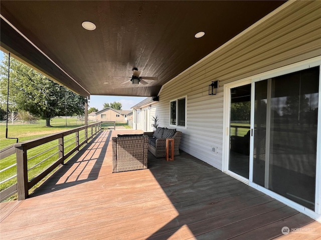 wooden terrace featuring a lawn and ceiling fan