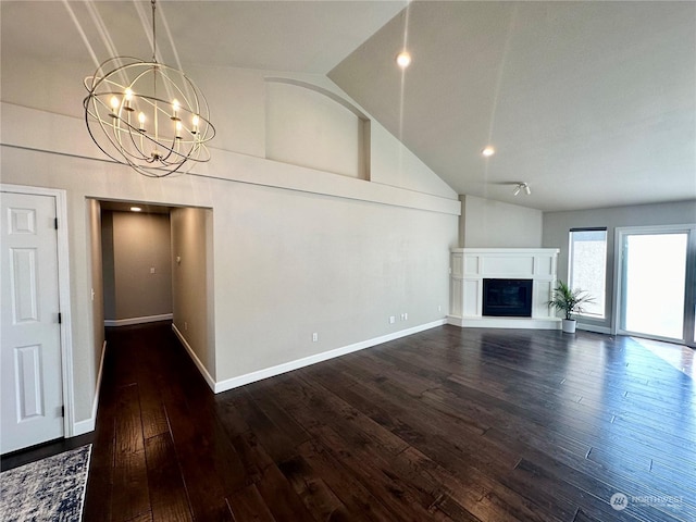 unfurnished living room featuring dark wood-type flooring, high vaulted ceiling, and a notable chandelier