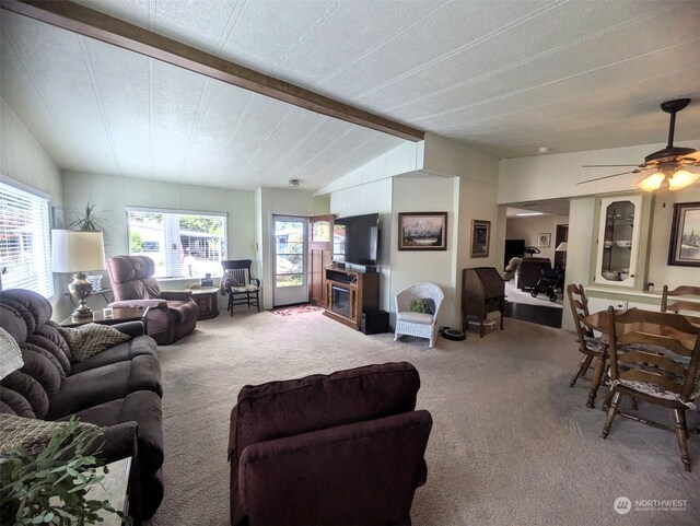 carpeted living room with ceiling fan and vaulted ceiling with beams