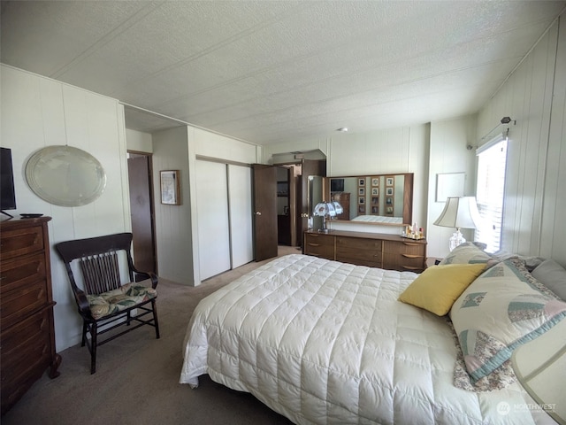 bedroom featuring a textured ceiling, a barn door, and carpet