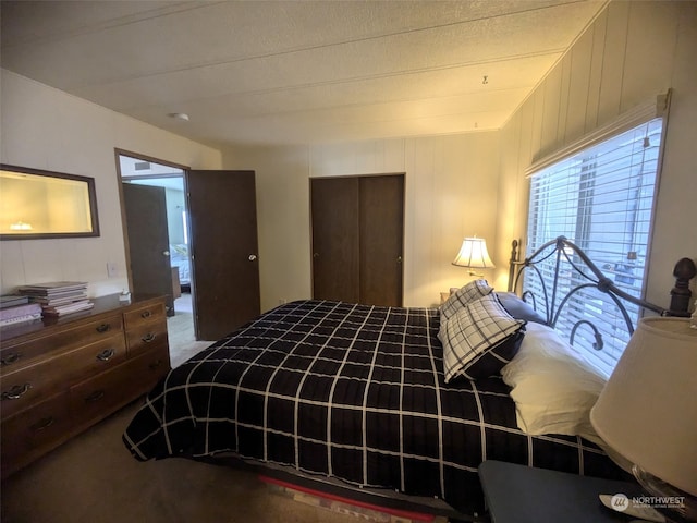 bedroom with a textured ceiling, carpet flooring, and a closet