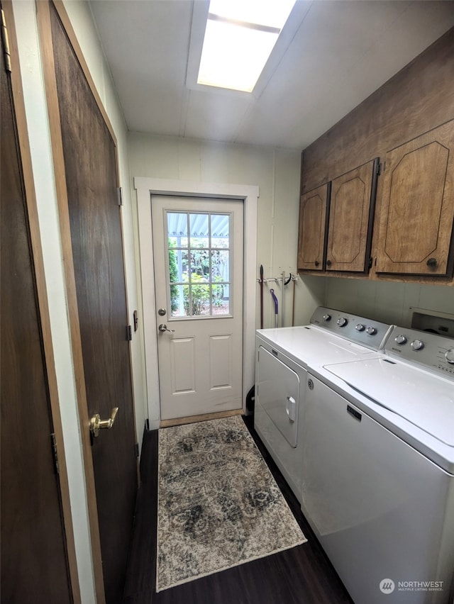 laundry area with hardwood / wood-style floors, cabinets, and washing machine and clothes dryer