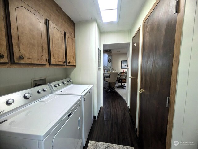 clothes washing area featuring washing machine and clothes dryer, cabinets, a skylight, and dark wood-type flooring