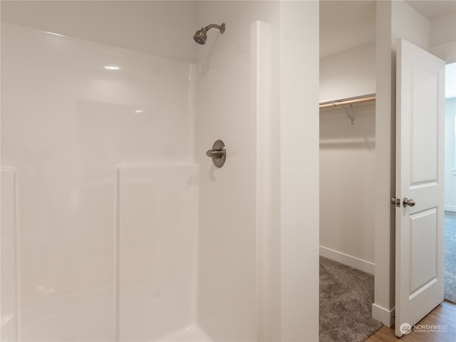 bathroom with hardwood / wood-style floors and walk in shower