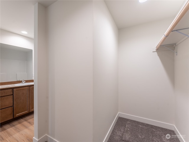 walk in closet featuring light hardwood / wood-style floors and sink