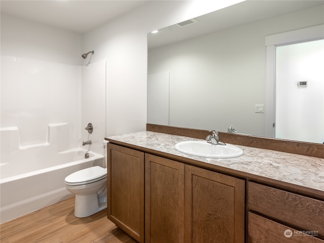 full bathroom featuring vanity, hardwood / wood-style floors, shower / bathing tub combination, and toilet