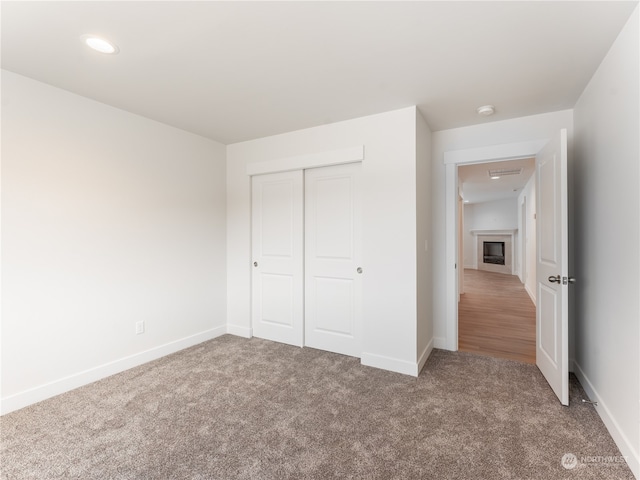 unfurnished bedroom featuring carpet flooring and a closet