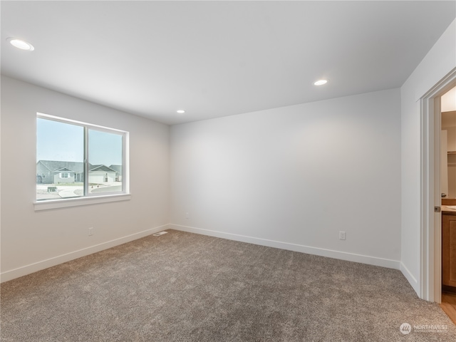 unfurnished room featuring light carpet