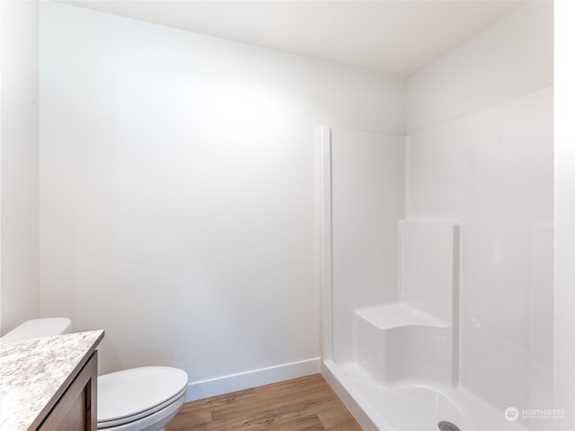 bathroom with vanity, hardwood / wood-style floors, toilet, and walk in shower