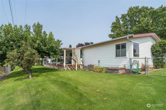 back of property featuring a lawn and fence