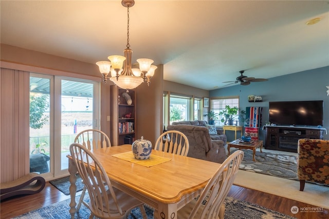 dining area with dark wood-style floors, vaulted ceiling, and ceiling fan with notable chandelier