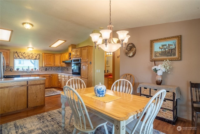 dining area with a chandelier, wood finished floors, and baseboards