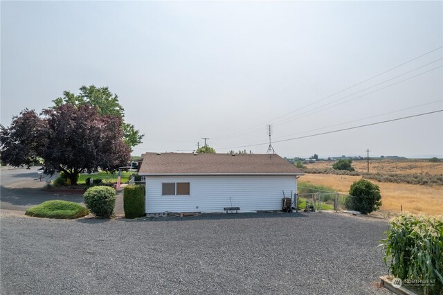 view of side of property with fence and driveway