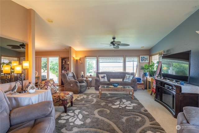 living room with light carpet, plenty of natural light, and a ceiling fan