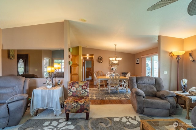 living room featuring vaulted ceiling, wood finished floors, and a notable chandelier