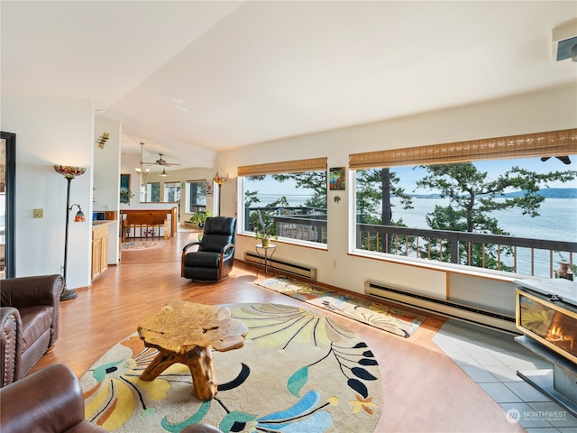 living room with a water view, a baseboard radiator, a wealth of natural light, and light hardwood / wood-style floors