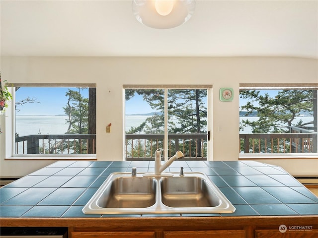 kitchen with tile countertops, a baseboard radiator, and a sink