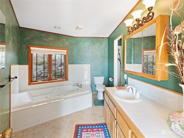 full bathroom featuring a garden tub, vanity, toilet, and a healthy amount of sunlight